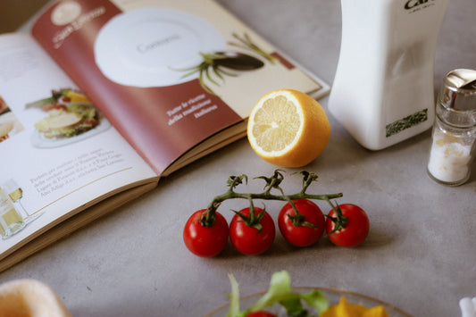A table topped with a plate of food and a book